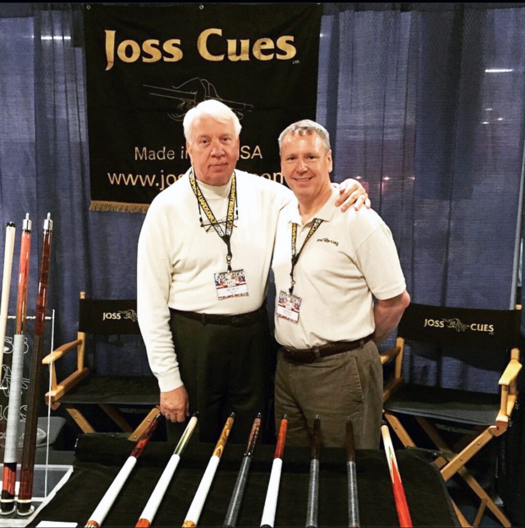 Two men at Joss Cues booth.